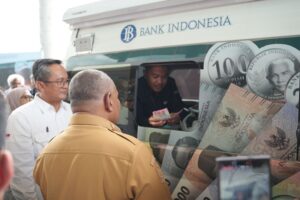 Wagub Papua Aryoko Rumaropen didampingi Kepala KPw Bank Indonesia Papua Faturahman saat menukar uang di mobil kas keliling
