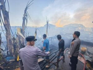 Aparat Kepolisian bersama warga berusaha memadamkan api